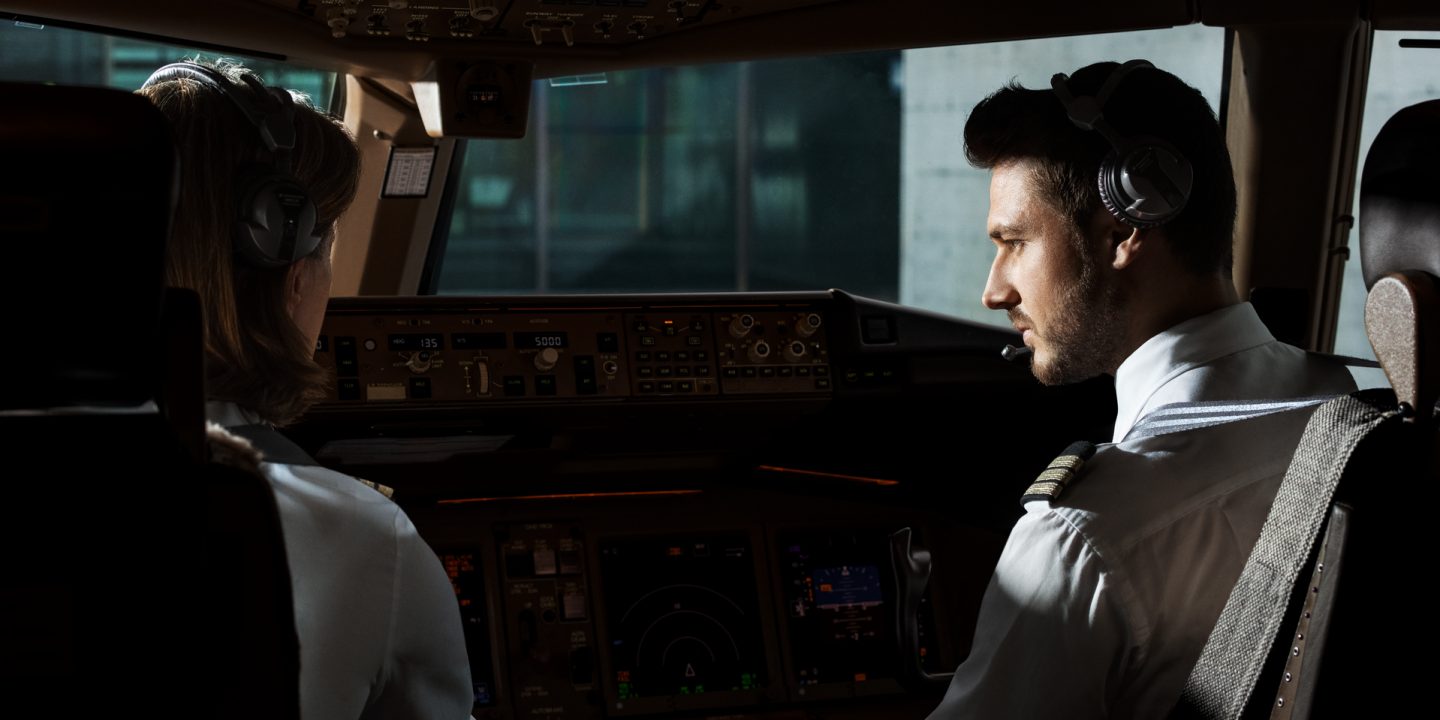 Professional pilots in the cockpit, focused and ready for flight.