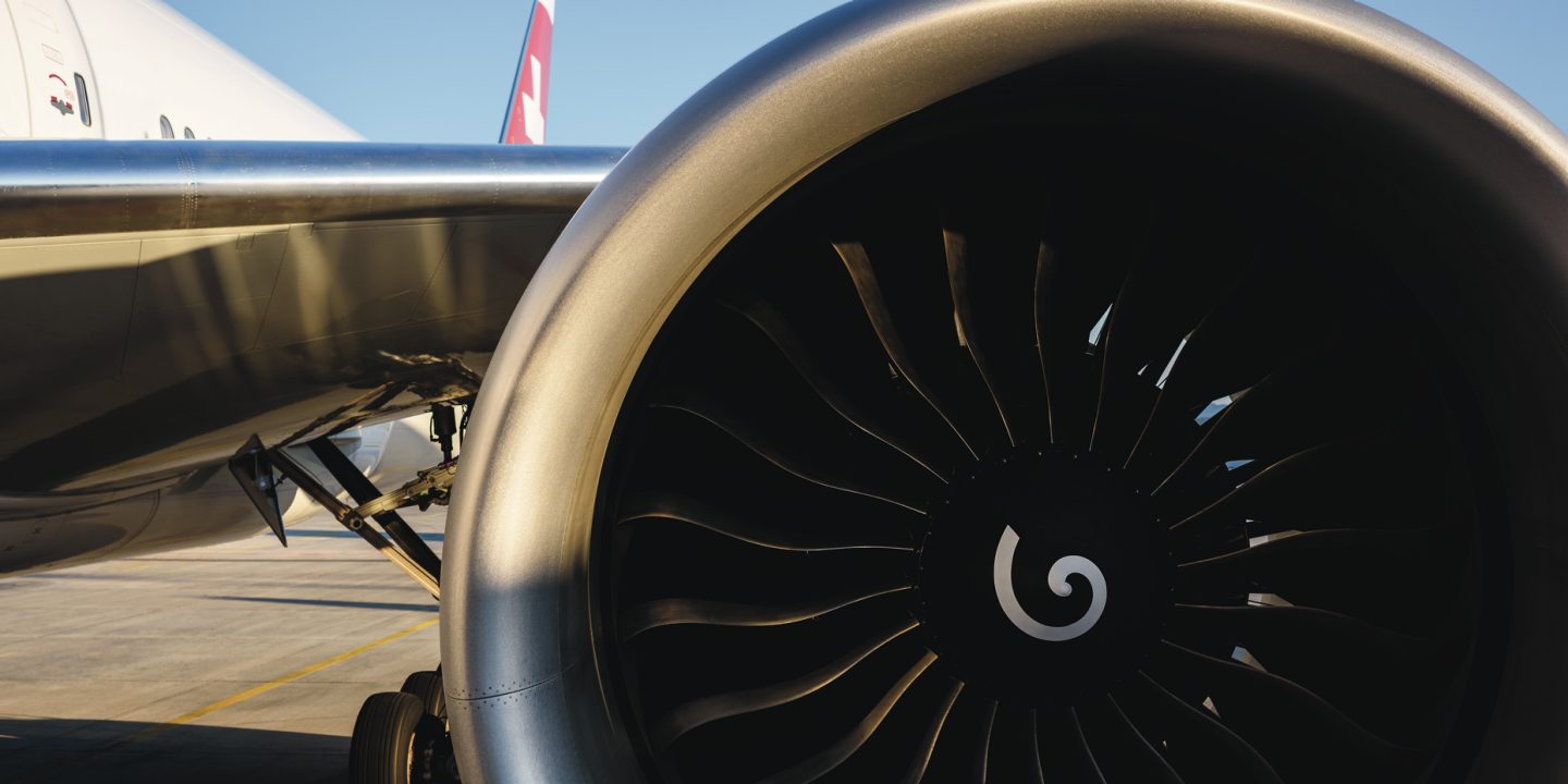 Close-up of a powerful jet engine, its fan blades ready for takeoff on the tarmac.
