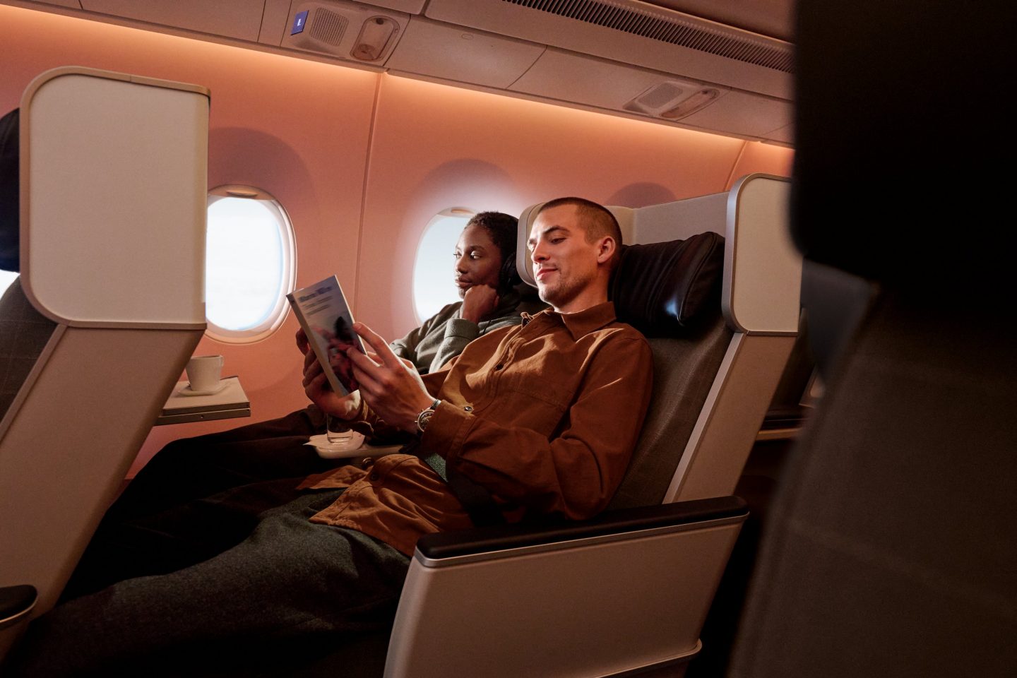 A couple relaxing in SWISS Premium Economy Class seats.