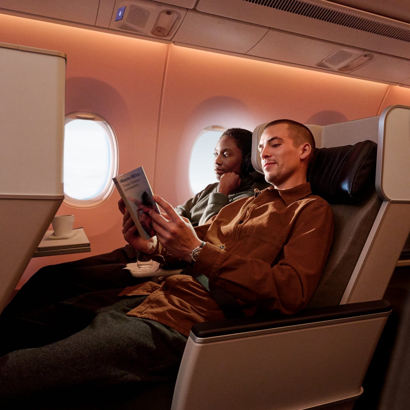 Deux passagers assis dans la Premium Economy Class de SWISS.