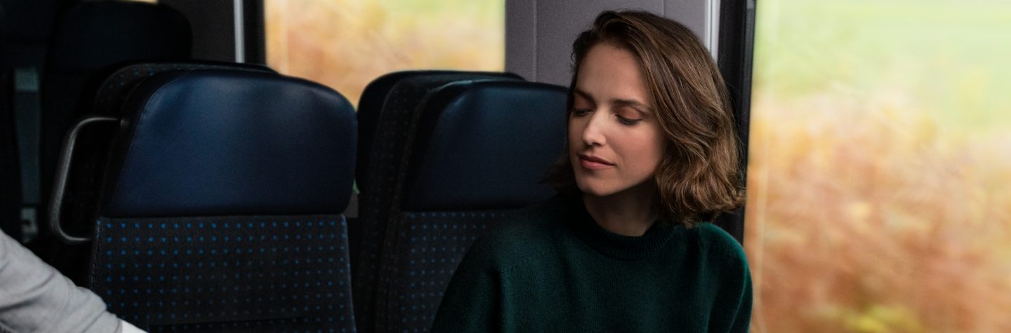 Woman has her mobile ticket scanned by an SBB employee on a train.