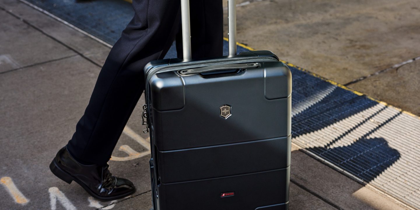 A man in black attire pulls a suitcase, possibly indicating the transport of dangerous goods.