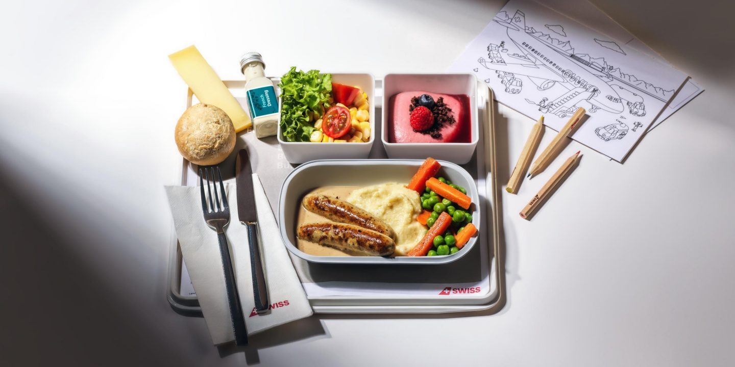A tray featuring assorted baby and child meals alongside utensils for easy feeding.