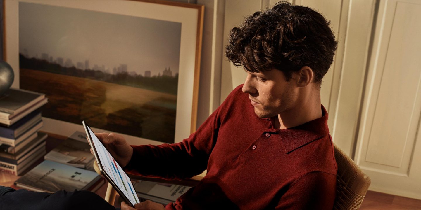 A man seated with a tablet, engaged in rebooking at short notice.