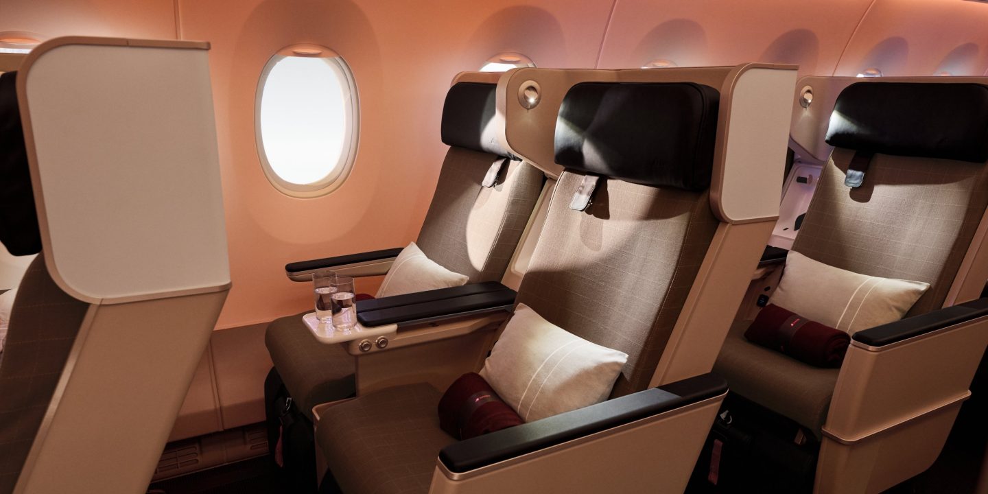 Bequeme Premium-Economy-Class-Sitze mit Kissen in einem modernen Flugzeug.