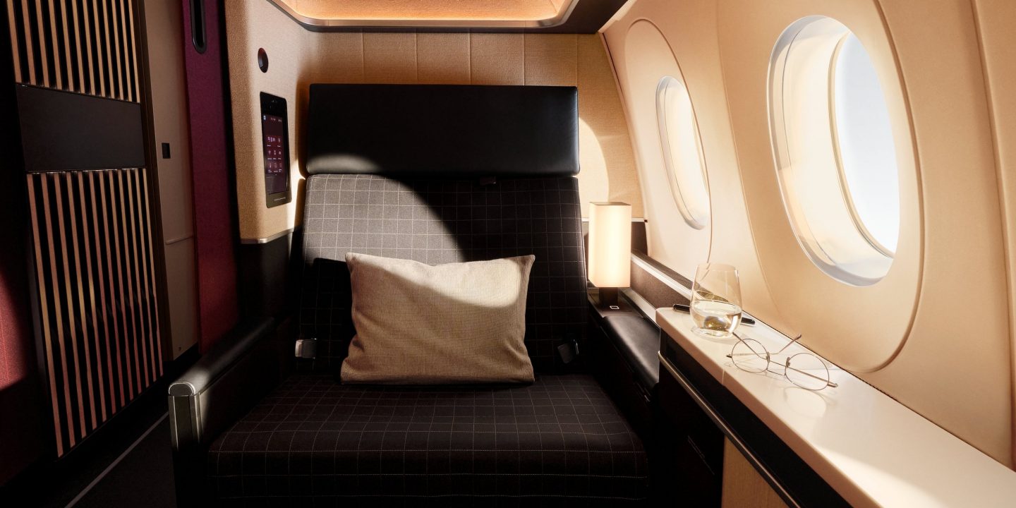 Luxuriöser First-Class-Sitz im Flugzeug mit Kissen und Fenster.