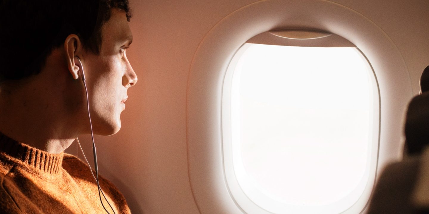 A passenger looking out the window of an airplane.