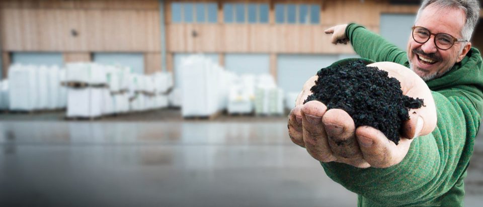 A man is holding a handful of soil.
