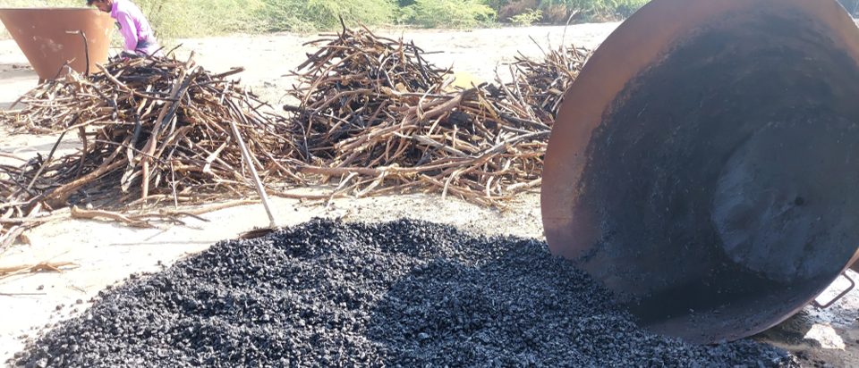 A large heap of black coal on the ground.