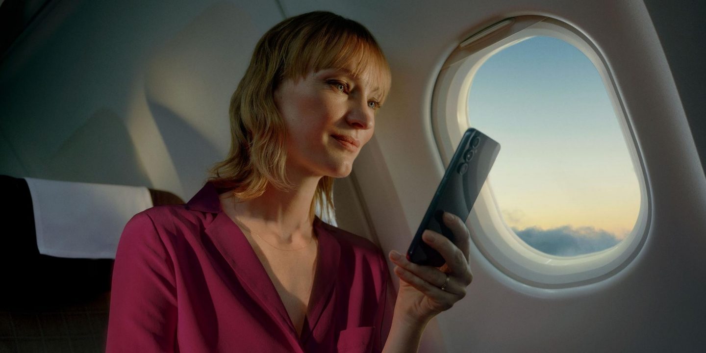 A passenger using a mobile connected to the onboard Wi-Fi during a flight.