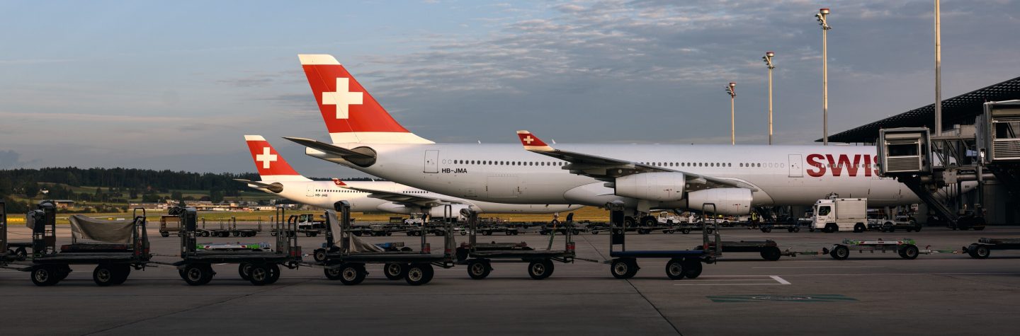 A passenger interacting with an in-flight entertainment screen in the SWISS cabin.