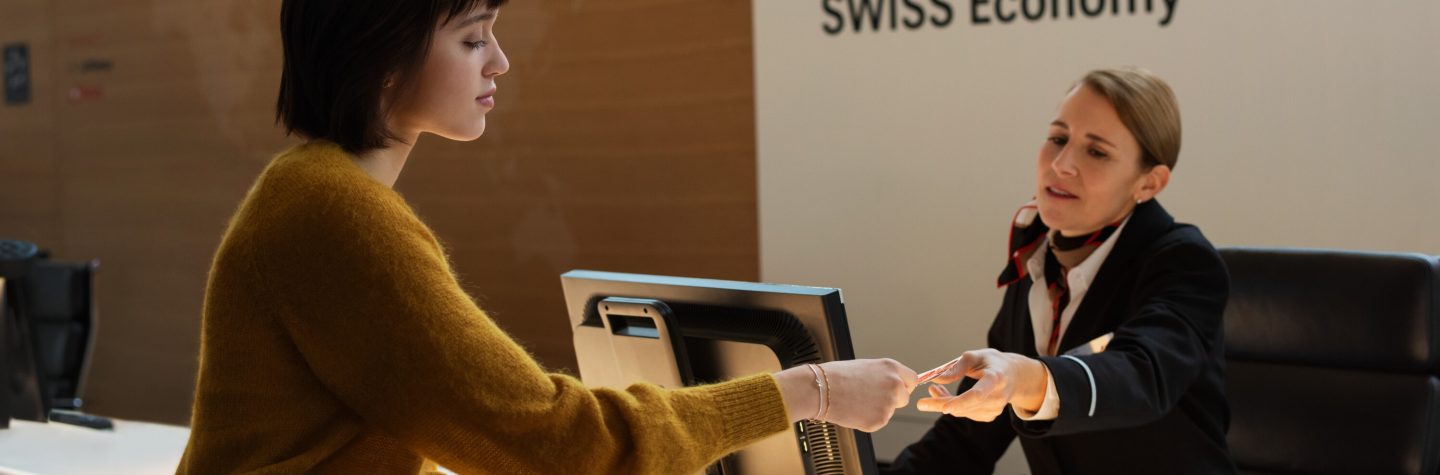 A woman and a man shake hands at a desk, symbolizing a professional agreement or partnership.