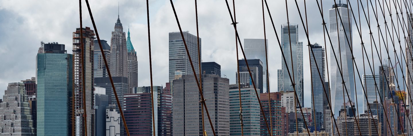 New York City skyline with the Brooklyn Bridge in the foreground.