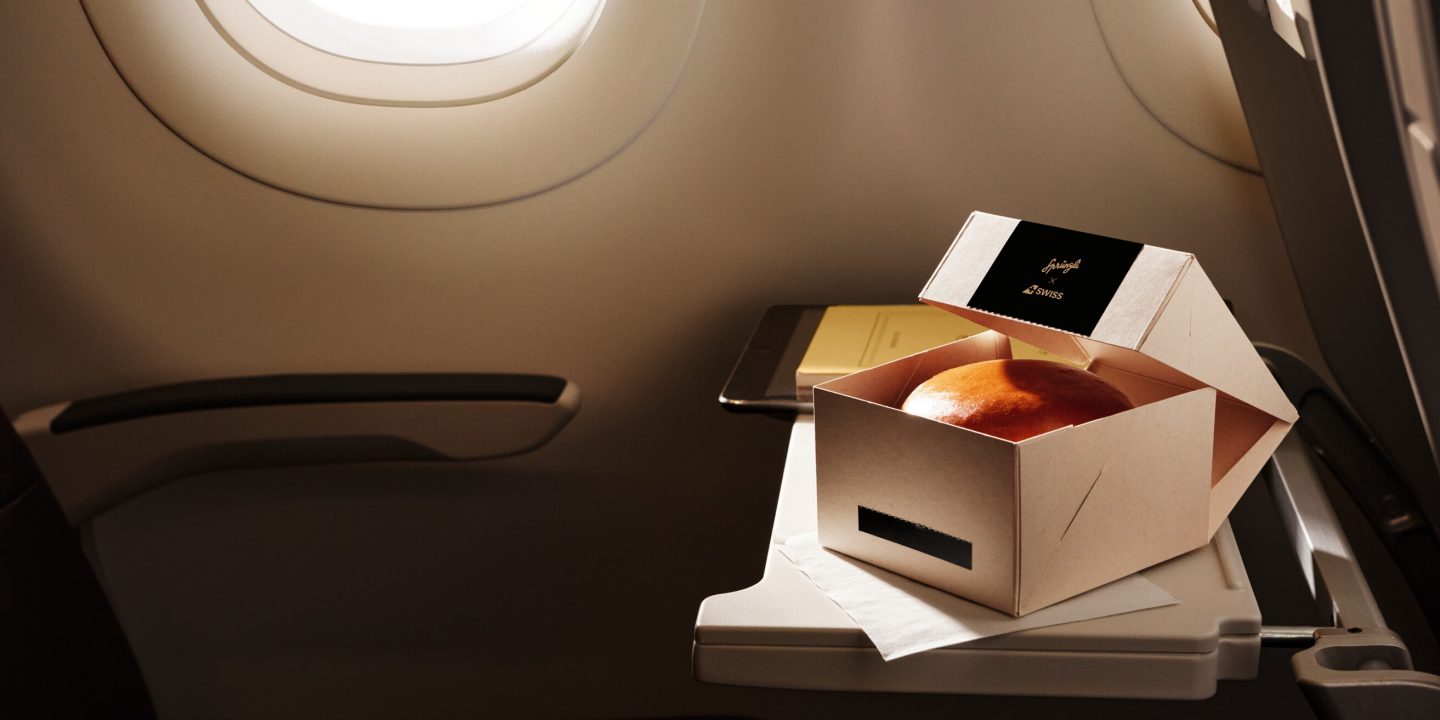 A meal box on a tray inside an airplane cabin.
