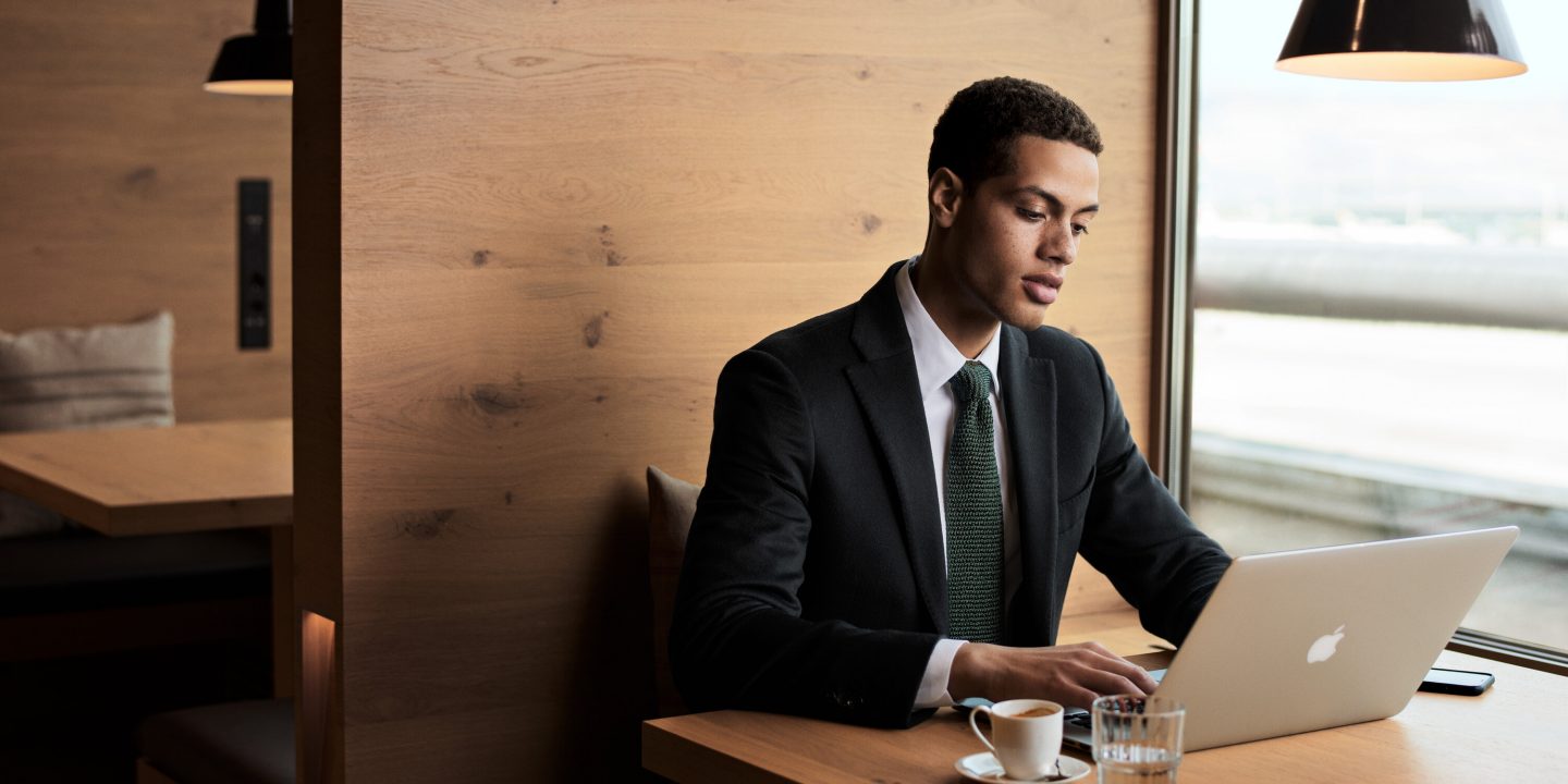 Professional working on laptop in a premium airport lounge.