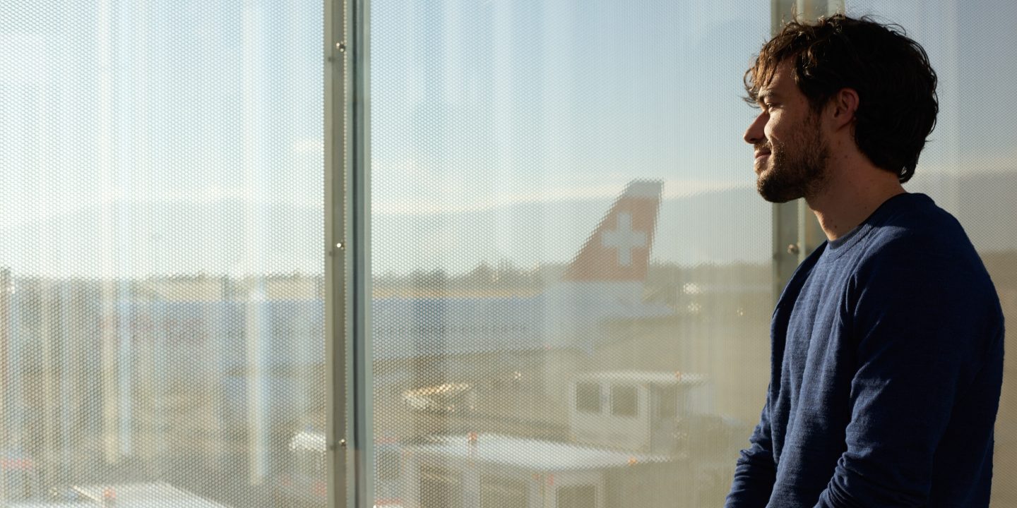 At Zurich Airport's Self Bag Drop, a man is positioned next to two suitcases.