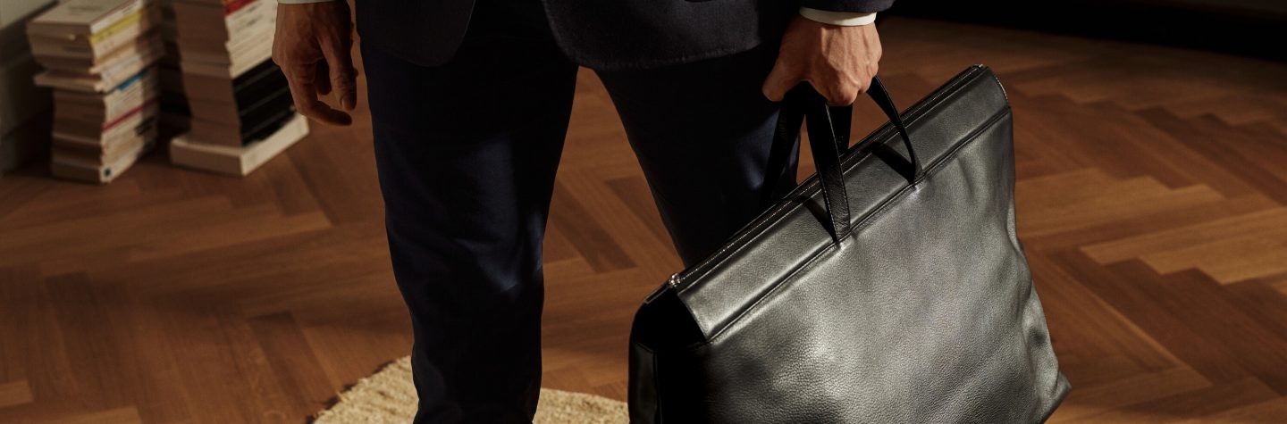 A man in a suit carrying a briefcase, ready for a business meeting or travel.