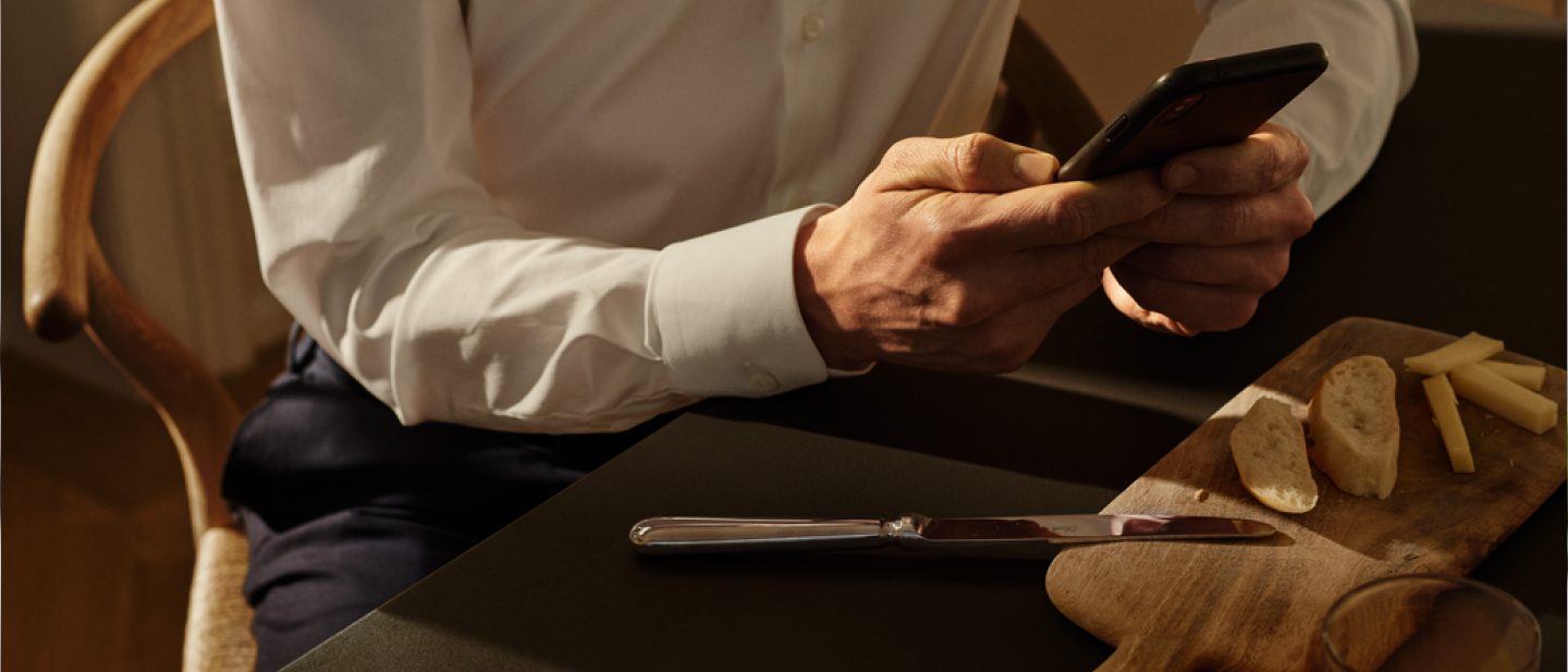 Mann bedient Smartphone im Sessel.