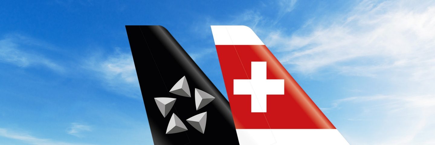 Star Alliance & SWISS airline tails together against a blue sky.