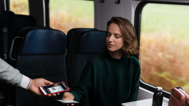 Woman in train showing her ticket to the controller.